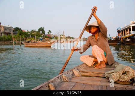 Old lady rowing in Hoi An Harbour, Vietnam, Indochina, Southeast Asia, Asia Stock Photo