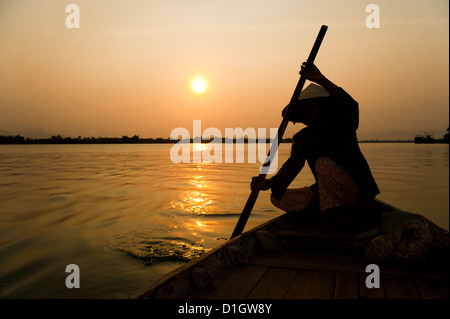 Old lady rowing in Hoi An harbour silhouetted at sunset, Vietnam, Indochina, Southeast Asia, Asia Stock Photo