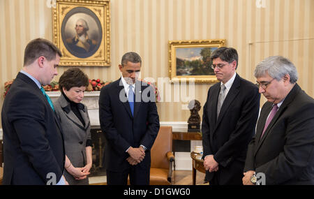 Washington, DC, USA. US President Barack Obama pauses during a meeting to observe a moment of silence in the Oval Office at 9:30 am December 21, 2012 in remembrance of the 20 children and six adults killed a week ago in the Sandy Hook Elementary School shooting in Newtown, CT. Joining the President, from left, are: Director of Communications Dan Pfeiffer; Senior Advisor Valerie Jarrett; Chief of Staff Jack Lew; and Pete Rouse, Counselor to the President. Stock Photo