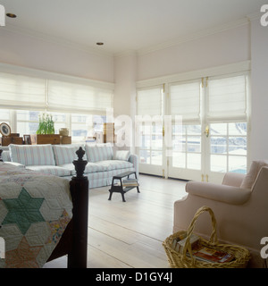 BEDROOMS Light and Airy bedroom view towards windows with white fabric shades Wood floor Sofa seating area partial view bed on Stock Photo