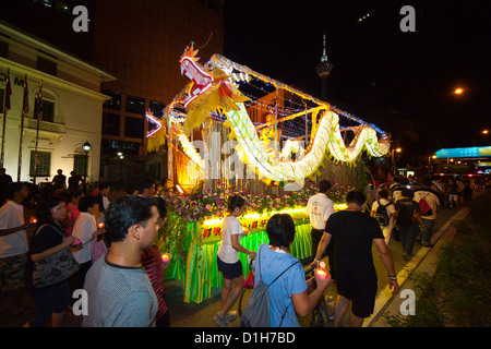 Devotees parading with floats during Wesak Day Procession in front the Museum Telekom building, Malaysia on May 5, 2012 Stock Photo