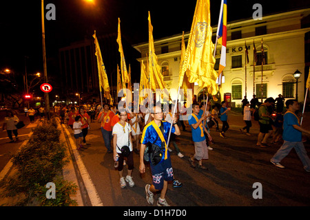 A group of devotees carry buddhish flags during Wesak Day procession on May 5, 2012 in front the Museum Telekom building, Malays Stock Photo