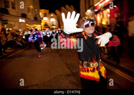Brighton, UK. Friday 21st December 2012. Crazy dancing from an elderly member of the parade. Burning the Clocks has been a Brighton tradition for almost two decades. This event takes place on the winter solstice, the shortest day of the year. A 2,000-strong parade winds its way through the streets and people pass their handmade paper and willow lanterns – filled symbolically with their hopes and dreams – into a blazing bonfire to “burn the clocks” and welcome in the new longer day. Stock Photo