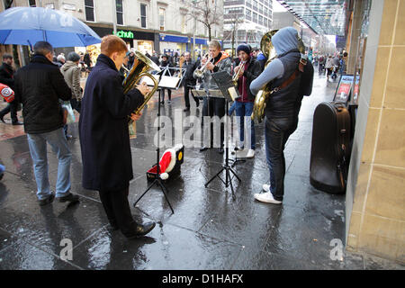 Sauchiehall Street, Glasgow, Scotland, UK, Saturday, 22nd December, 2012. Buskers entertaining people Christmas shopping in the city centre rain Stock Photo