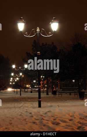 row of lanterns in park at winter night Stock Photo