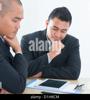 Southeast Asian business people discussing, sitting in office. Stock Photo