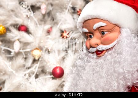 The doll in the form of Santa Claus on a white background Christmas tree with toys Stock Photo