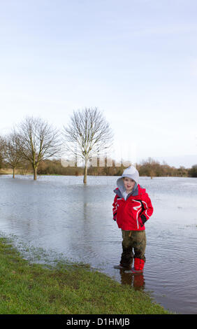 Braintree, Essex, UK. Sunday 23 December 2012. Braintree, Essex, UK. A young boy stands in the floodwaters at Blackwater local nature reserve after the River Blackwater burst it banks due to heavy rain over the weekend. Stock Photo