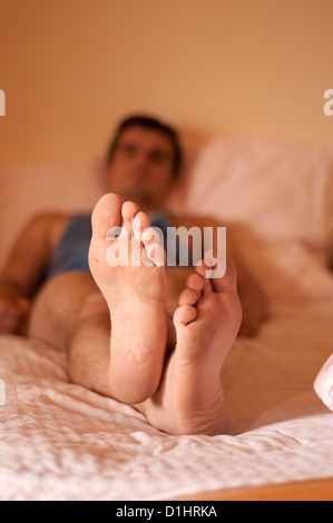 Man relaxing in bed Stock Photo