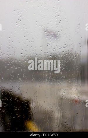 Rainy windows - abstract of flag on a windy and rainy day through a cafe windows in Waterhead, near Ambleside Stock Photo