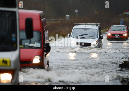 Derwenlas, Ceredigion Wales UK. Monday 24 December 2012. Cars driving through floodwaters on the A487 trunk road at Derwenlas, Ceredigion, near Machynlleth. Despite the road being officially closed traffic still attempted to negotiate the road, with some becoming stuck in the water.  Photo: Keith Morris/Alamy Live News Stock Photo