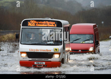 Derwenlas, Ceredigion Wales UK. Monday 24 December 2012. Cars driving through floodwaters on the A487 trunk road at Derwenlas, Ceredigion, near Machynlleth. Despite the road being officially closed traffic still attempted to negotiate the road, with some becoming stuck in the water.  Photo: Keith Morris/Alamy Live News Stock Photo