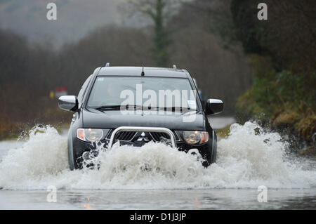 Derwenlas, Ceredigion Wales UK. Monday 24 December 2012. Cars driving through floodwaters on the A487 trunk road at Derwenlas, Ceredigion, near Machynlleth. Despite the road being officially closed traffic still attempted to negotiate the road, with some becoming stuck in the water.  Photo: Keith Morris/Alamy Live News Stock Photo