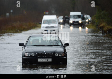 Derwenlas, Ceredigion Wales UK. Monday 24 December 2012. Cars driving through floodwaters on the A487 trunk road at Derwenlas, Ceredigion, near Machynlleth. Despite the road being officially closed traffic still attempted to negotiate the road, with some, like this BMW car,  becoming stuck in the water.  Photo: Keith Morris/Alamy Live News Stock Photo