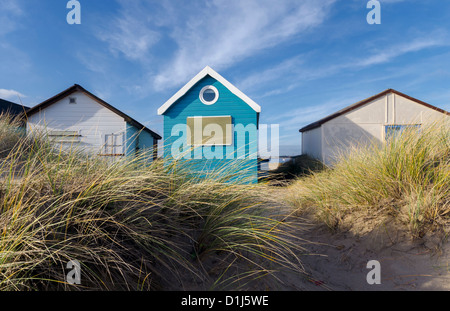 Beach huts and boats in sand dunes at Mudeford Spit on Hengistbury Head near Christchurch in Dorset. Stock Photo