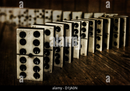Rows of lined up old ivory and ebony bronze pinned standing domino blocks pieces on Victorian pine table wooden panel behind Stock Photo