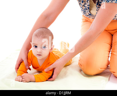 Mother helping her little son raise on the hands Stock Photo