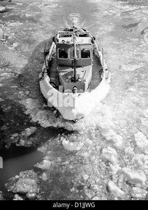 Tug breaking the ice on the river Elbe in the port of Hamburg. Stock Photo