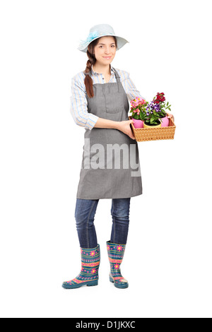 Full length portrait of a female gardener holding flower plants isolated on white background Stock Photo