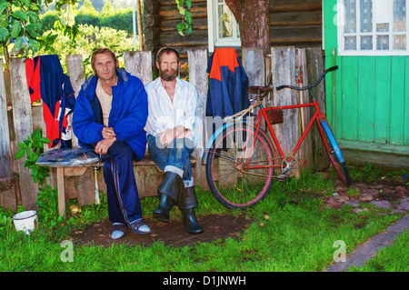 Portrait of two brothers sitting on a bench near the house. Stock Photo