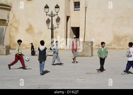 Children playing football in a square in Fez, Morocco Stock Photo