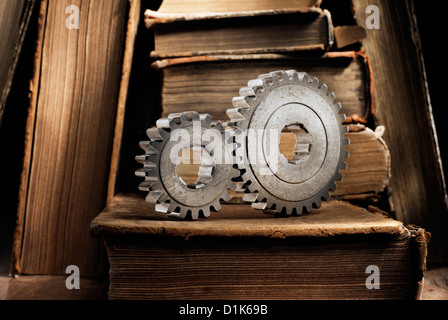 Still life with old metallic cog gears and antique books. Short depth of field. Stock Photo