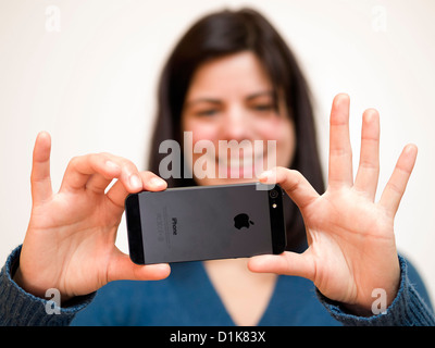 Young woman taking photos with iPhone 5 smartphone Stock Photo