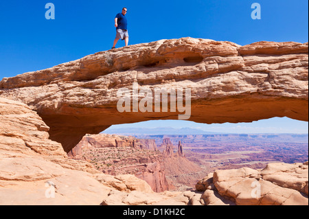 Man walking on the top of Mesa Arch, Island in the Sky Canyonlands National Park Utah USA United States of America us Stock Photo