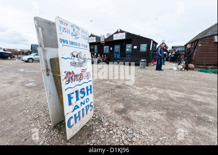 A sign for a fish and chip shop at Southwold harbour Suffolk UK with the fish sheds in the backfround Stock Photo