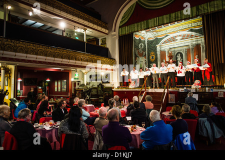 People enjoying a Victorian themed Solstice night Xmas celebration in the ornate former music hall now Ceredigion Museum UK Stock Photo