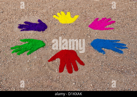 Coloured powder hand prints in a circular pattern on a dirt track Stock Photo