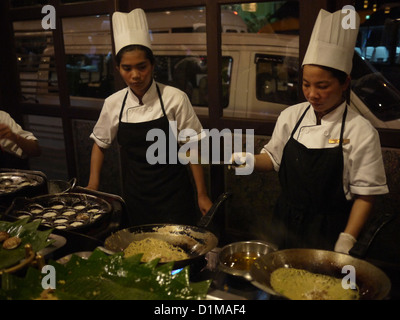 female chef frying noodle Asian buffet Stock Photo