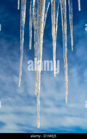 Frozen Icicles Isolated over Blue Sky with clouds Stock Photo