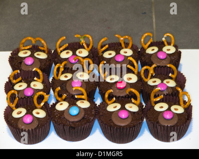 A tray of chocolate fairy cakes with amusing faces made with chocolate buttons Stock Photo
