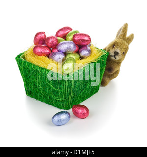 Basket with chocolate candy Easter eggs and bunny on white background Stock Photo