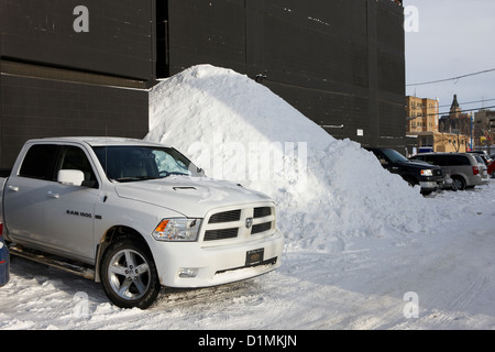 huge pile of snow cleared from parking lot in Saskatoon Saskatchewan Canada Stock Photo