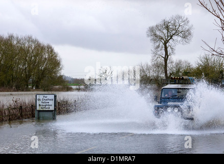 Motorists braving floods at Melksham in Wiltshire after heavy rains caused the River Avon to burst its banks Stock Photo