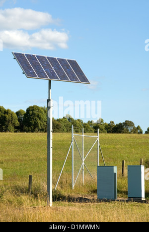 A solar panel, to generate electricity to provide lighting for a road sign at night Stock Photo