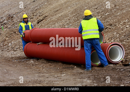 Construction site pipe workers Stock Photo