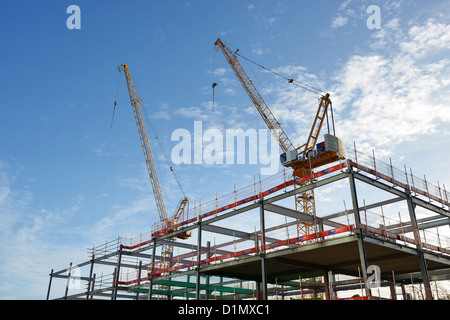 Steel frame and two cranes on a UK construction site Stock Photo