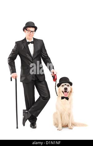 Full length portrait of a magician with bow tie holding cane and dog isolated on white background Stock Photo