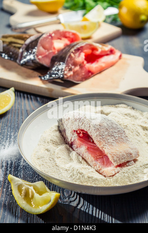 Fish in the seasoned flour for frying lemon on a plate Stock Photo