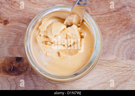 https://l450v.alamy.com/450v/d1n7wj/peanut-butter-and-knife-in-a-glass-jar-on-wooden-table-d1n7wj.jpg