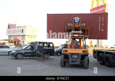 Fork Lifter put container to close the road leads towards  Seaview Beach to control law and order situation on the occasion of New Year, at Defence area  in Karachi on Monday, December 31, 2012. Stock Photo