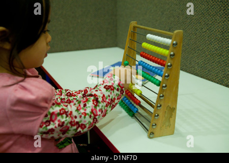 Asian toddler girl using abacus Stock Photo