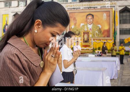Jan. 1, 2013 - Bangkok, Thailand - Women pray for a prosperous 2013 in front of a portrait of Bhumibol Adulyadej, the King of Thailand, hanging on the front of Bangkok City Hall, during a special merit making ceremony New Year's morning. Many Thais go to Buddhist temples and shrines to ''make merit'' for the New Year. The traditional Thai New Year is based on the lunar calender and is celebrated in April, but the Gregorian New Year is celebrated throughout the Kingdom. (Credit Image: © Jack Kurtz/ZUMAPRESS.com) Stock Photo