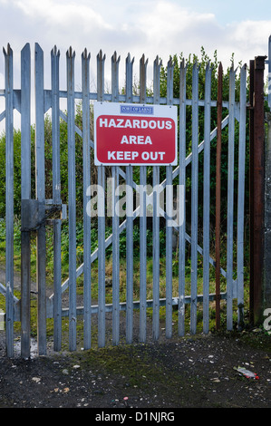 Sign on a security gate warning 'Hazardous area. Keep out'