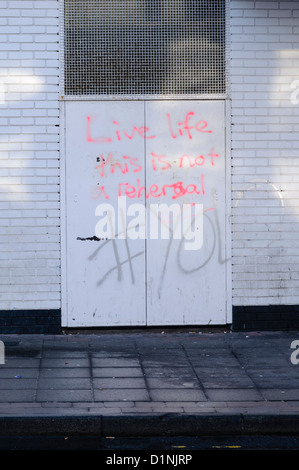 Graffiti on doors saying 'Live life, this is not a rehersal #YOLO' (you only live once) Stock Photo
