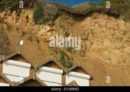 Swanage cliff overhang by beach huts at the northern end of Swanage bay Stock Photo