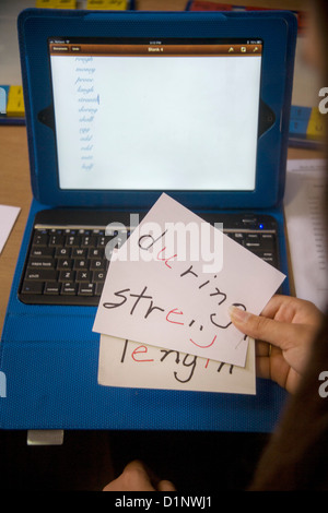 Sight words for a dyslexic child are juxtaposed with the computer she has used in an attempt to spell them from dictation. Stock Photo